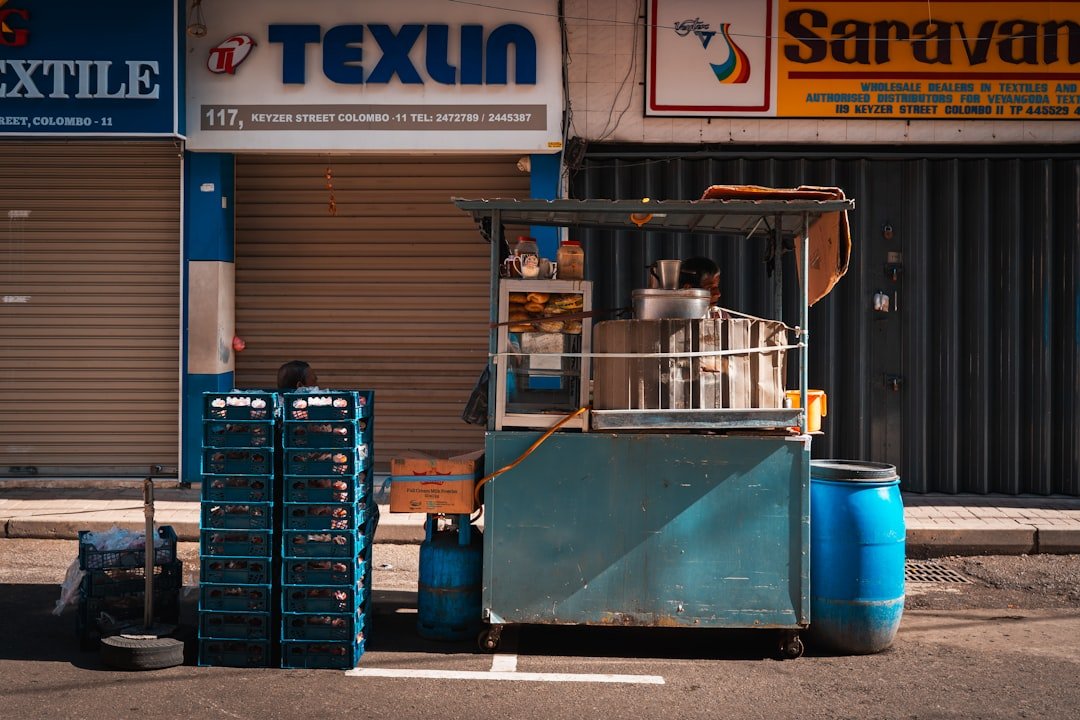 A blue street food cart stands before closed storefronts