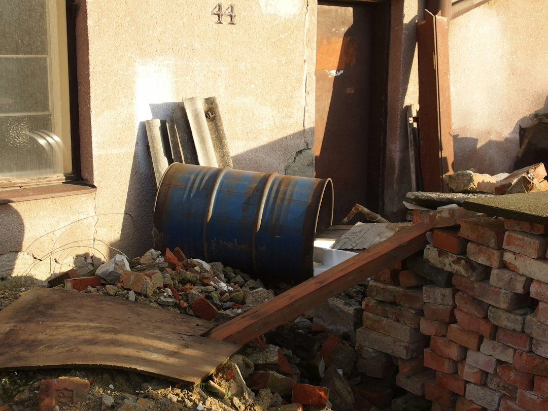 blue plastic drum beside brown wooden ladder