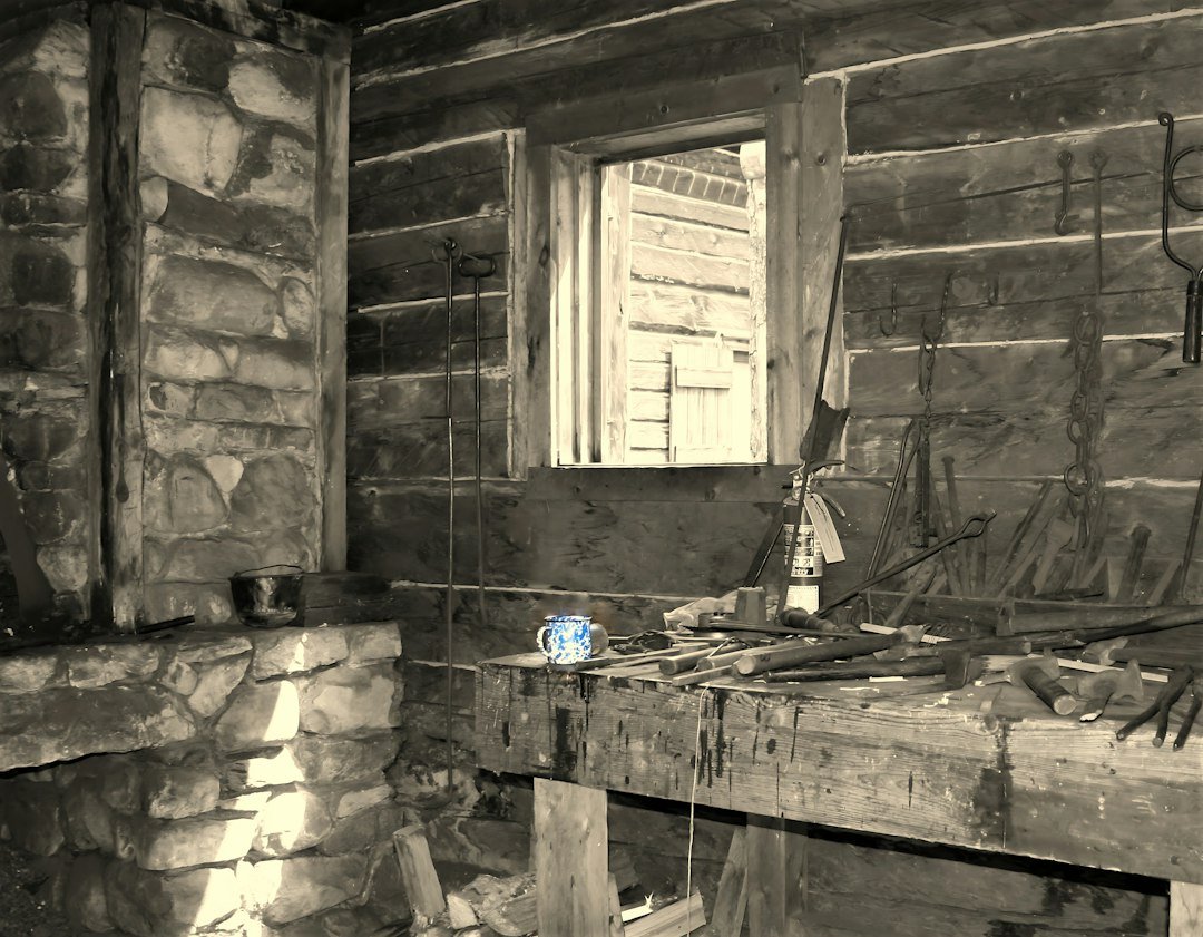 Rustic log cabin interior with stone fireplace and wooden workbench