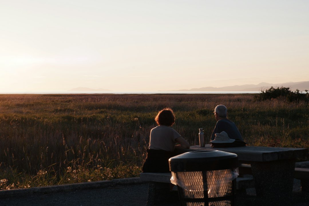 a couple of people sitting at a picnic table